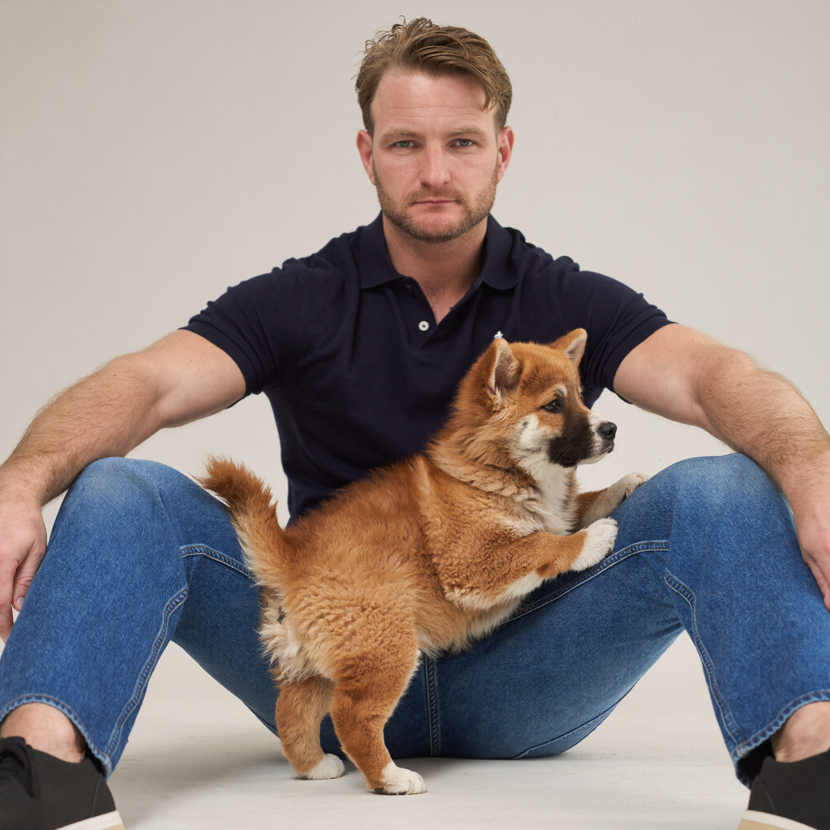 Luke Buchanan from The Toe Beans Co with an Akita puppy.